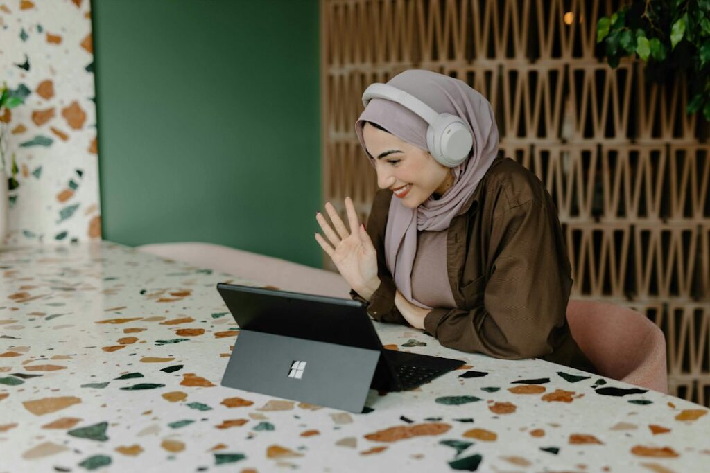 Persona seduta al tavolo mentre utilizza un computer portatile